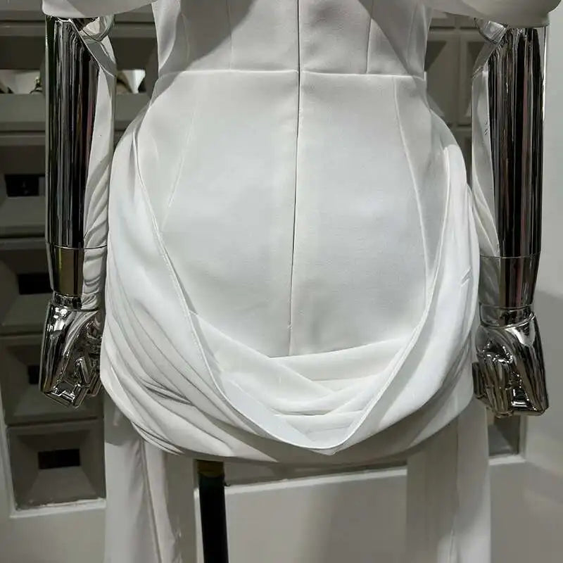 White dress on a mannequin with silver armrests against a neutral background