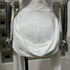 White dress on a mannequin with silver armrests against a neutral background