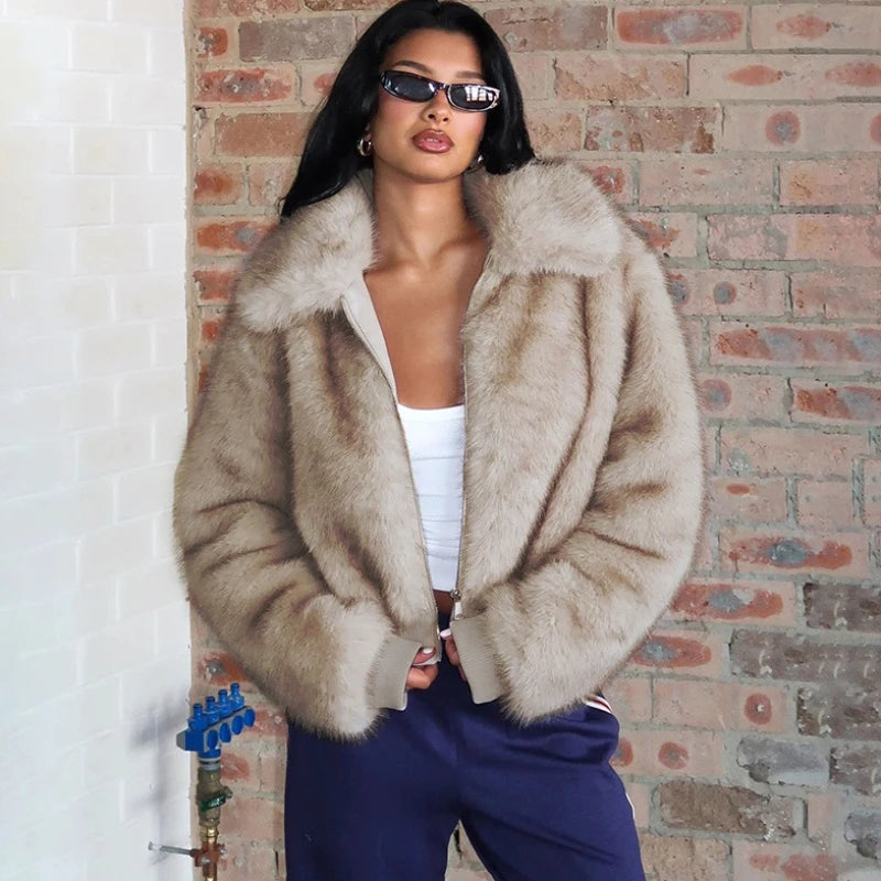 Woman wearing a fur coat and sunglasses against a brick wall.