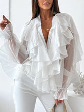 White ruffled blouse worn by a model on a white background