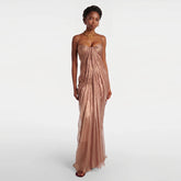 Model wearing a floor-length ruched spaghetti strap evening gown.