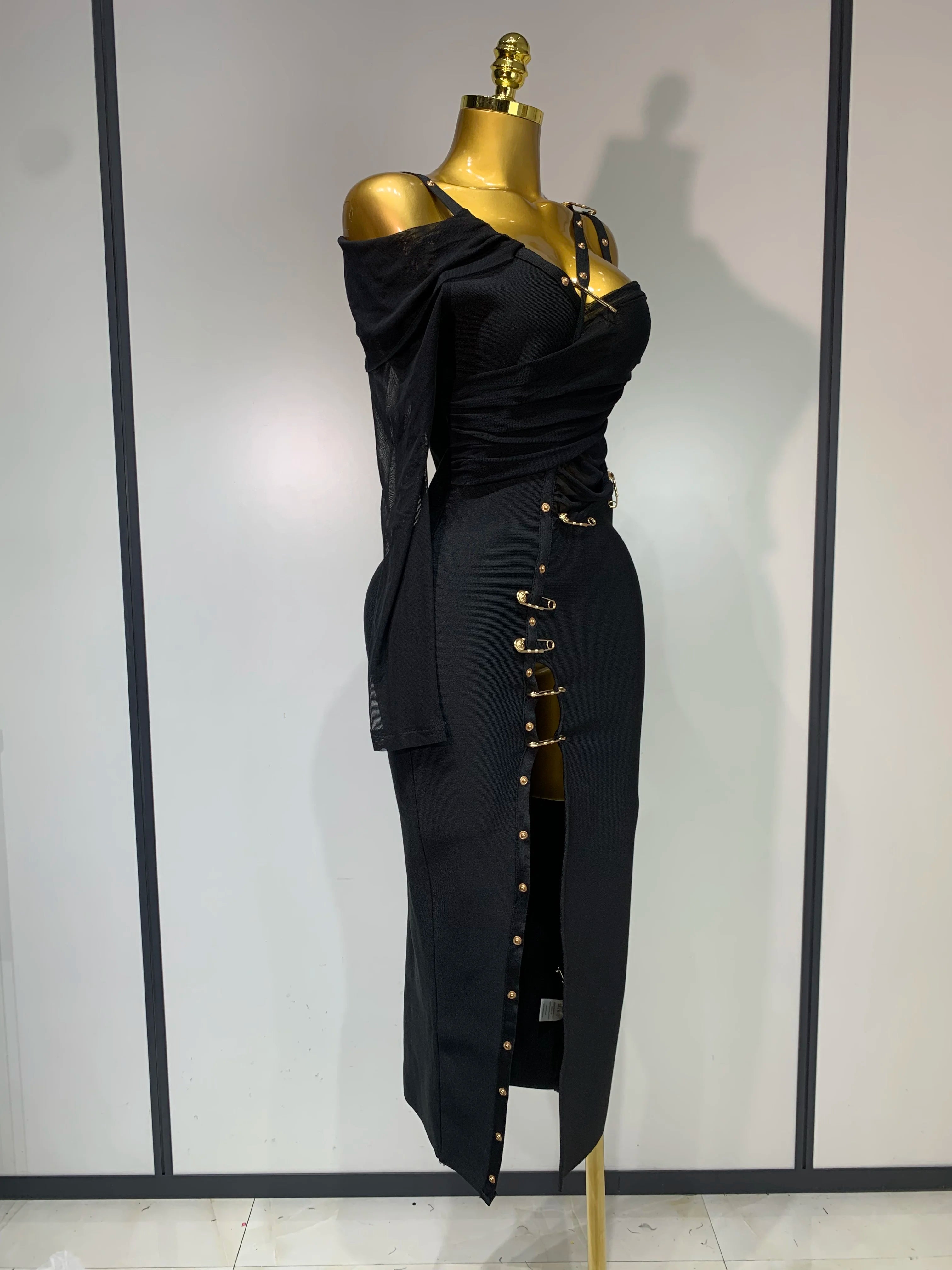 Black dress on a mannequin against a plain background