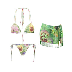 Floral print bikini and green beaded skirt laid flat.
