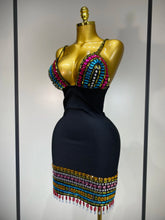 Black dress with colorful beading on a mannequin against a neutral background