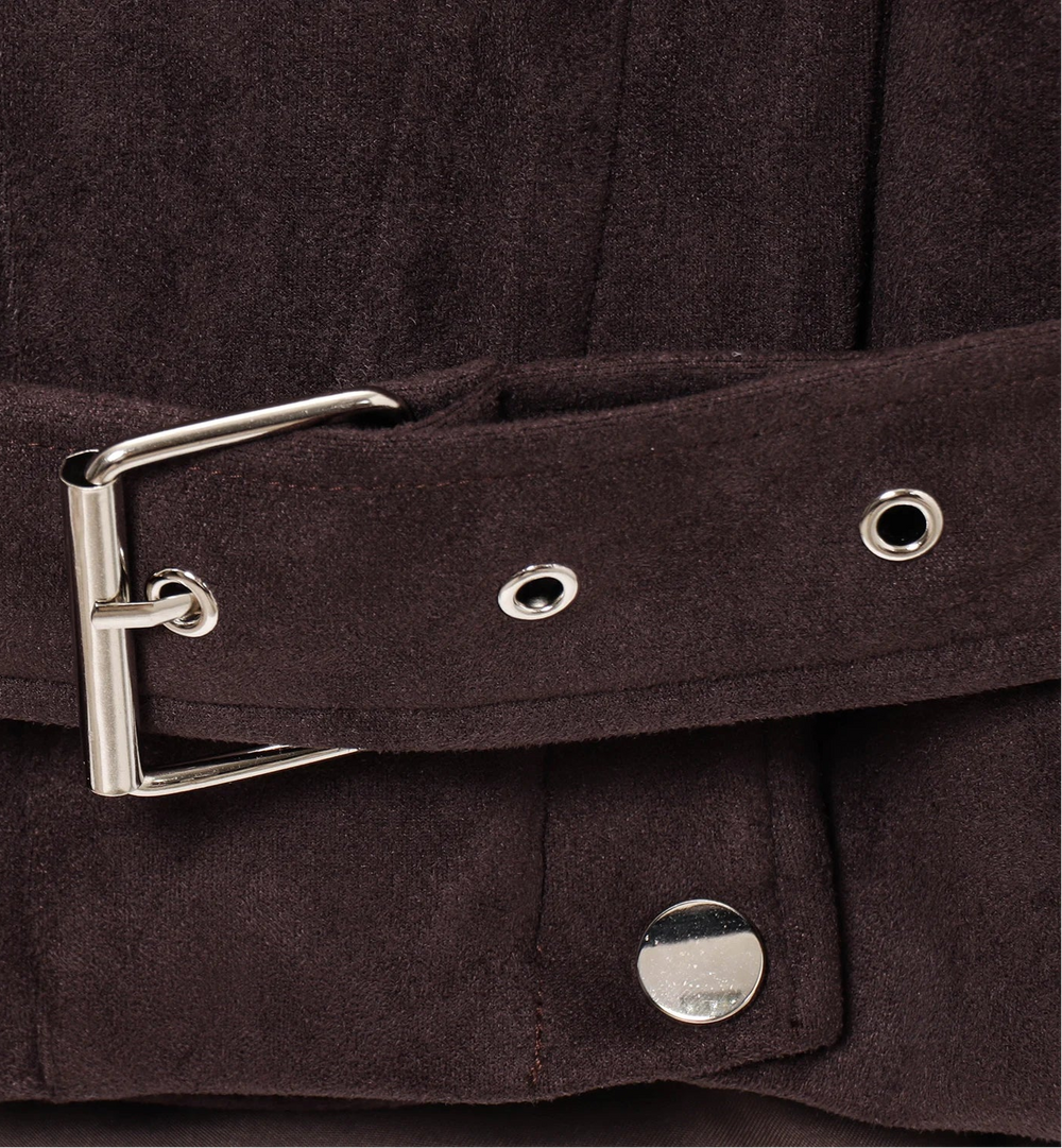 Close-up of a brown belt with a silver buckle on a dark background