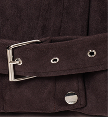 Close-up of a brown belt with a silver buckle on a dark background