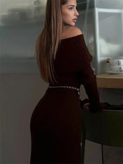 Woman in a dark brown off-shoulder dress standing in a modern kitchen.