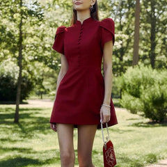 Woman wearing a red dress with puff sleeves in a park setting