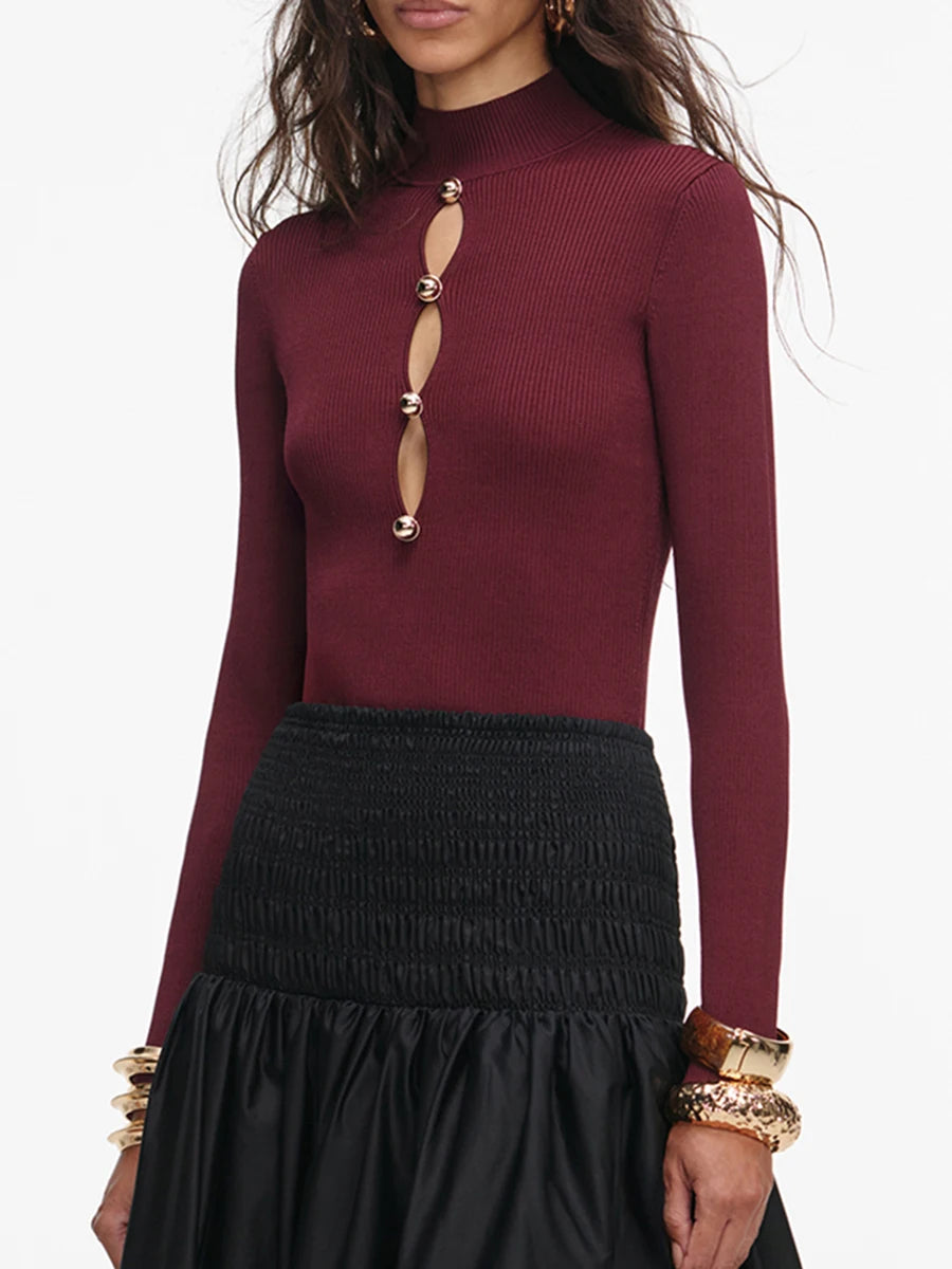 Maroon long-sleeve top with cut-out design and black skirt on a white background