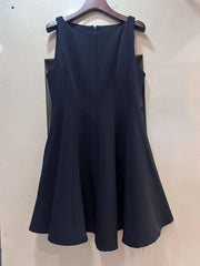 Navy blue dress on a hanger against a white wall