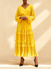 Woman wearing a yellow tiered dress against a beige background