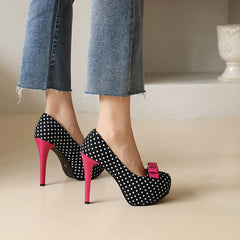 Black polka dot bow platform heels on feet