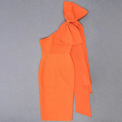 Orange one-shoulder dress with a bow detail on a gray background
