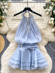 Light blue dress on a hanger with floral decorations in the background