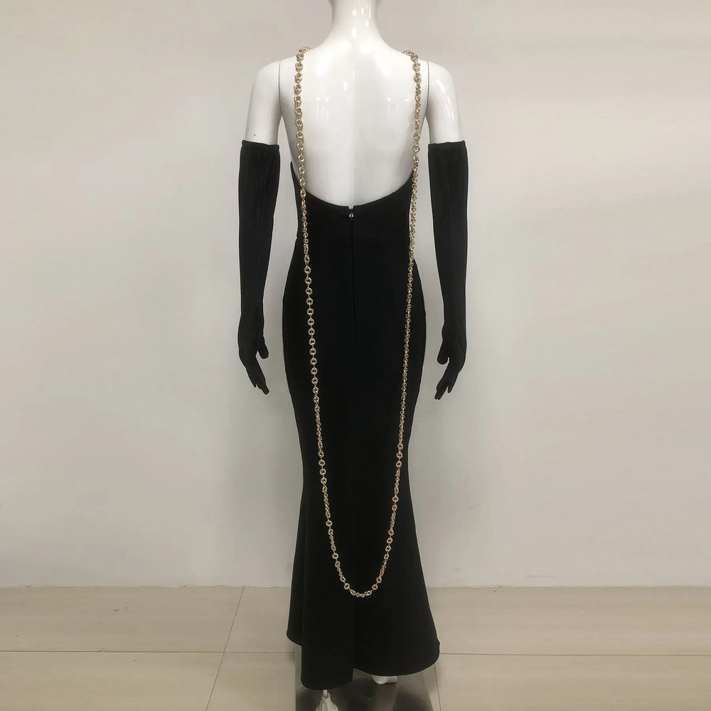 Black evening gown with long train on a mannequin against a plain background