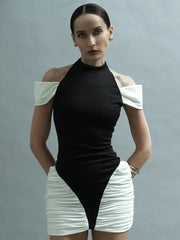 Woman wearing a black and white outfit against a gray background