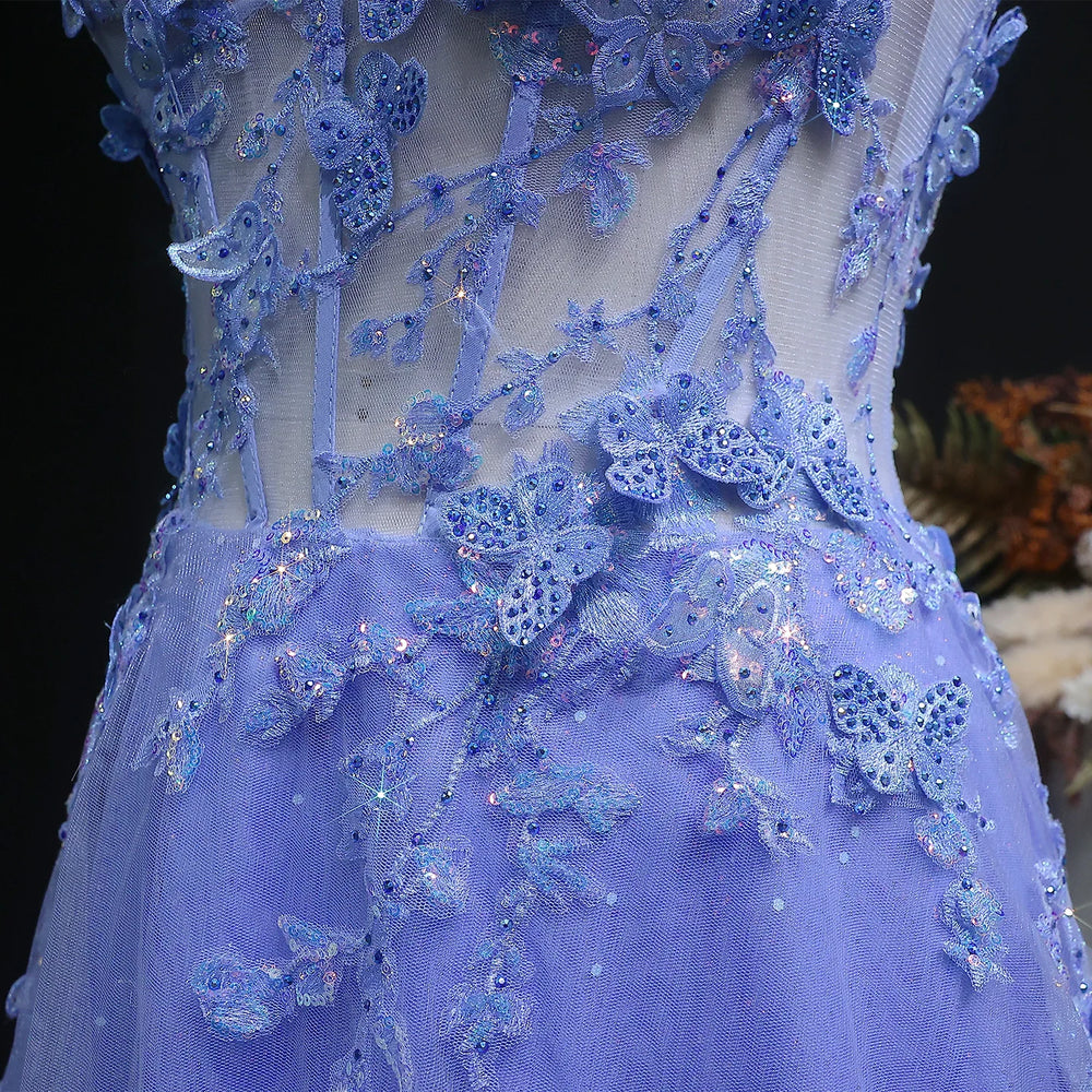 Close-up of a blue embroidered dress with butterfly details on a dark background