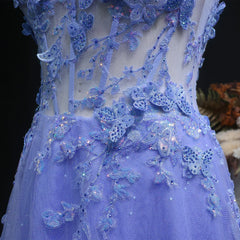 Close-up of a blue embroidered dress with butterfly details on a dark background