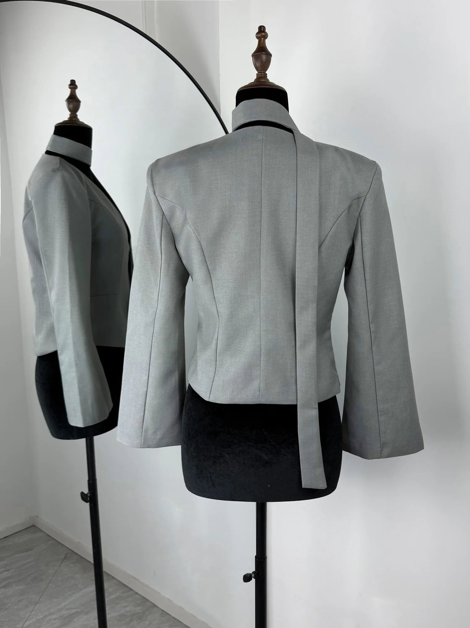 Gray blazer on a mannequin against a white background