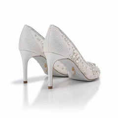 Pair of silver high-heeled shoes with intricate detailing on a white background
