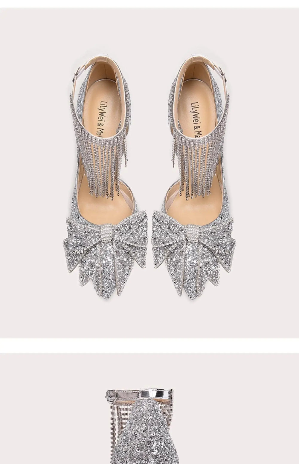 Silver high-heeled shoes with fringe details on a light pink background