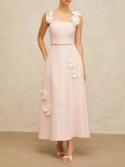 Pink two-piece outfit with floral details on a neutral background