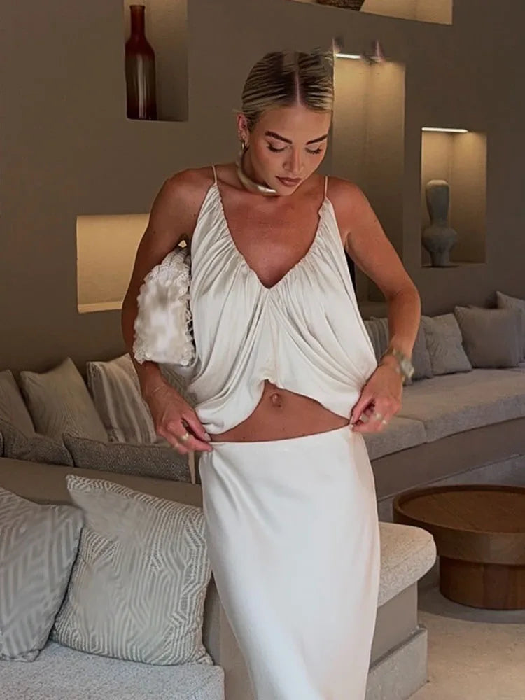 Woman in a white dress standing in a living room.