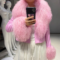 Person wearing a pink fluffy jacket taking a selfie in a store setting with mannequins.