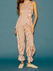 Woman wearing a red and white striped jumpsuit against a blue background