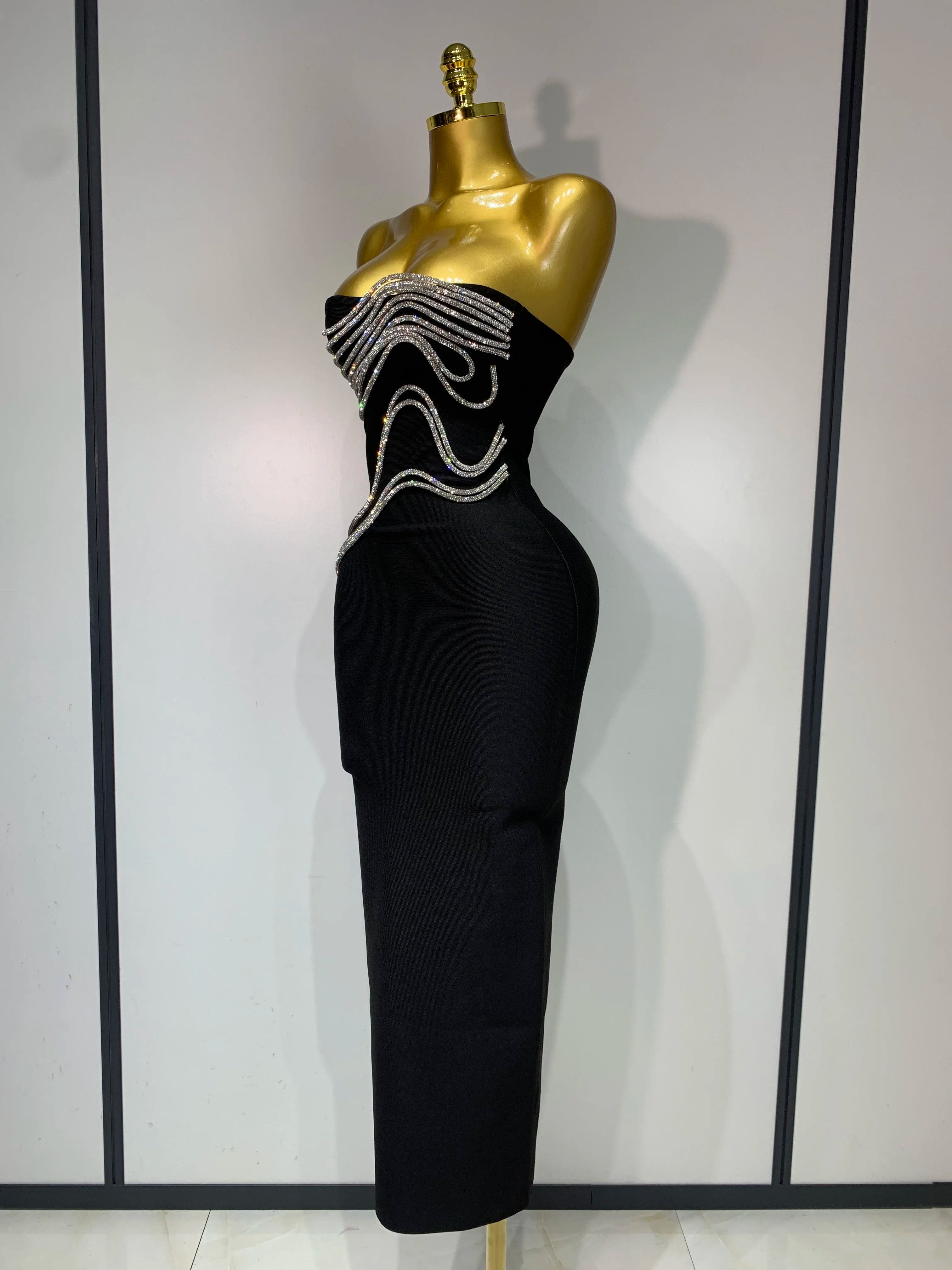 Black strapless dress with bead embellishments on a mannequin against a plain background