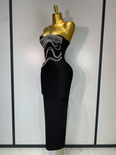 Black strapless dress with bead embellishments on a mannequin against a plain background