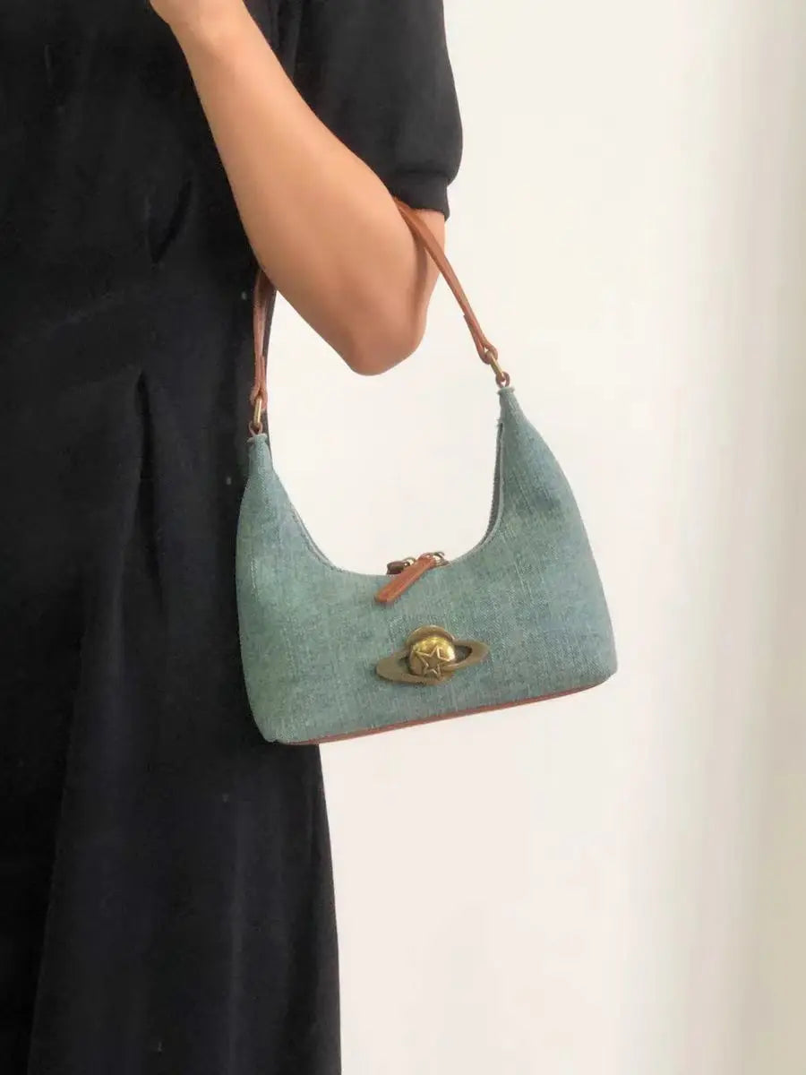 Person holding a green handbag with a plain background