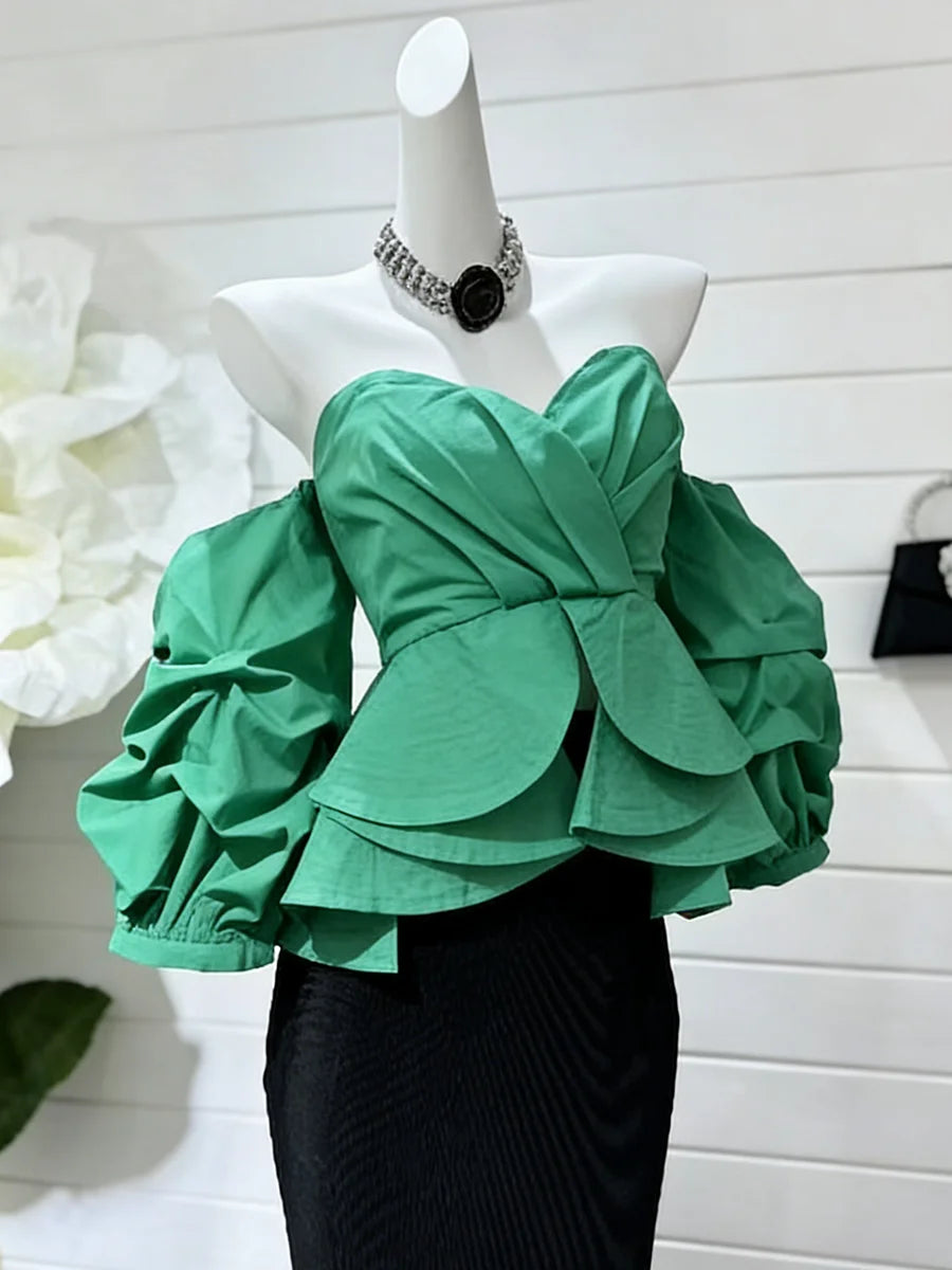 Green ruffled top on a mannequin with a white background