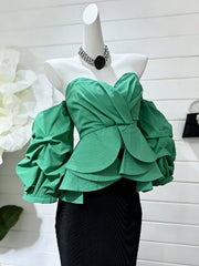 Green ruffled top on a mannequin with a white background