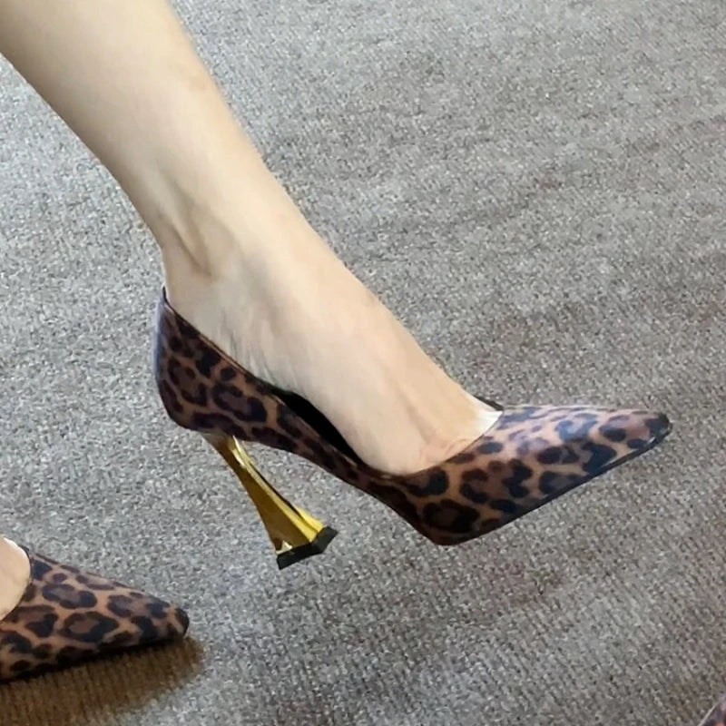 Leopard print high heels with gold heel on a gray carpet