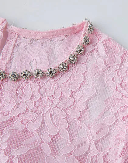 Pink lace garment with a decorative neckline on a light gray background