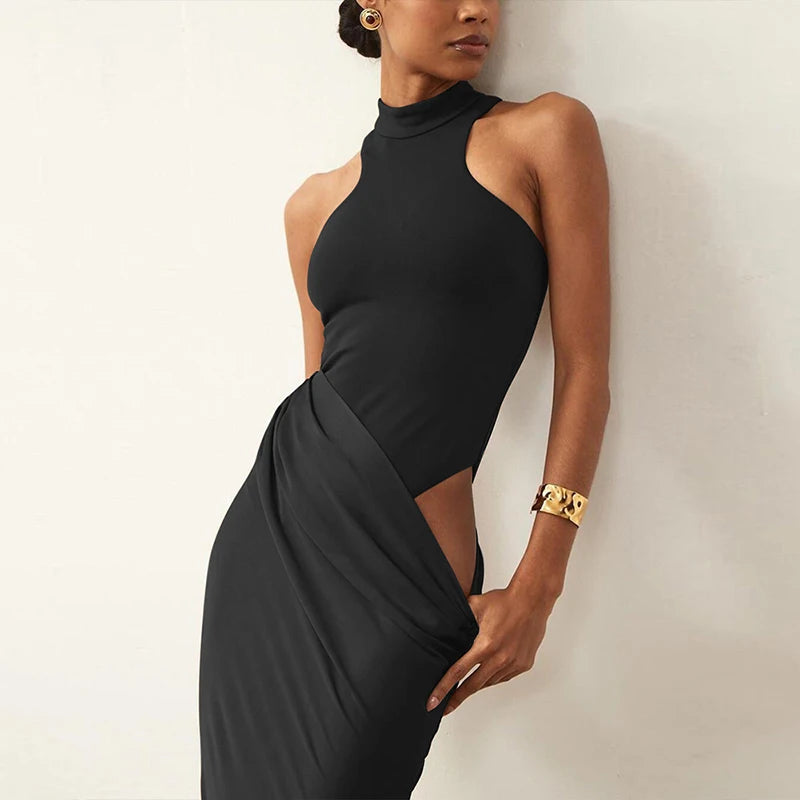 Woman wearing a black halter neck dress with cut-out design against a plain background