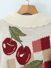 Knitted sweater with cherry design on a hanger against a white background