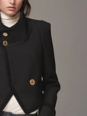 Black coat with gold buttons on a plain background