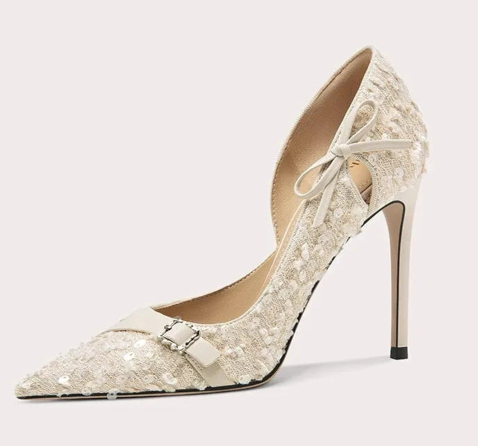 High-heeled shoe with decorative bow on a light gray background