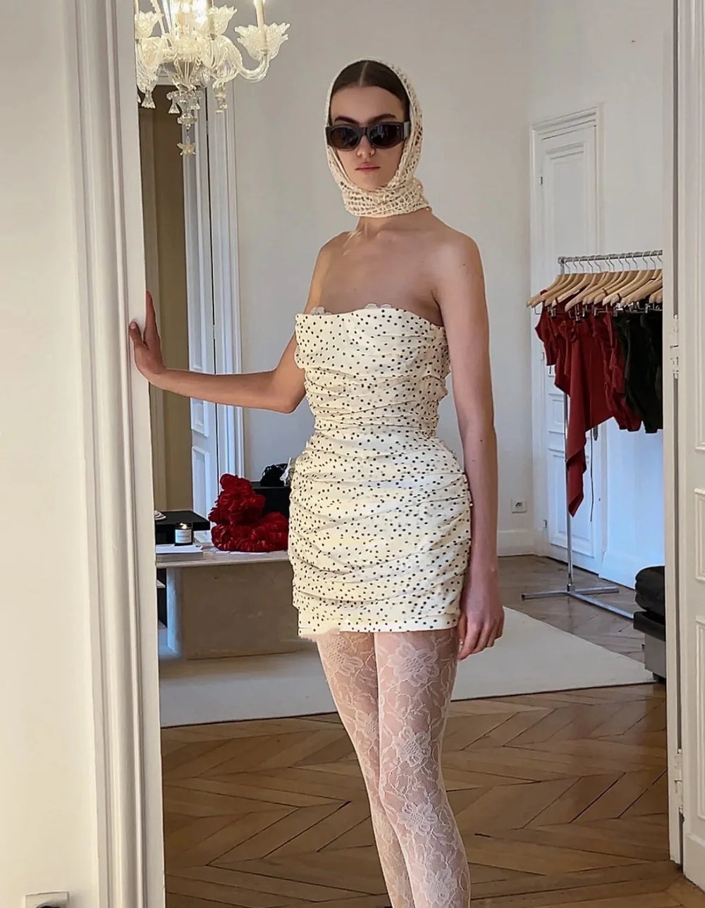 Woman wearing a strapless dress with a hood in an indoor setting.