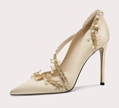 Beige high-heeled shoe with floral embellishments on a white background