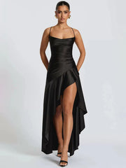 Woman wearing a black satin dress with a high slit on a white background