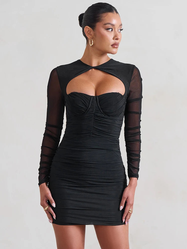 Black dress with sheer sleeves worn by a model on a plain background
