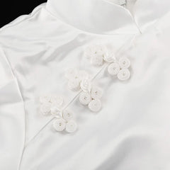 White blouse with floral button details on a white background