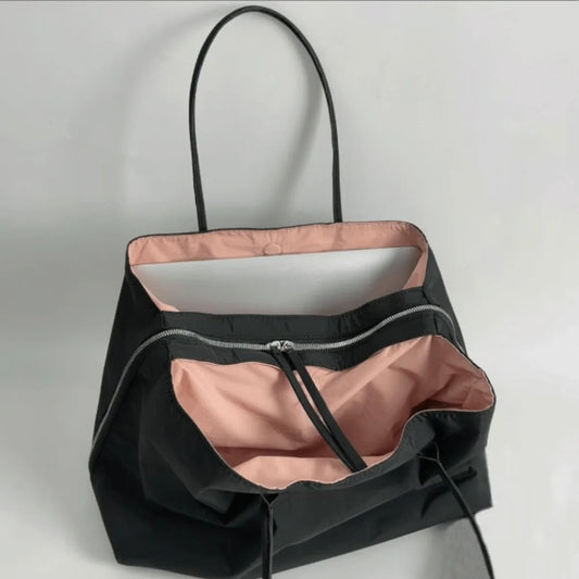 Black nylon tote bag with pink lining and silver zipper