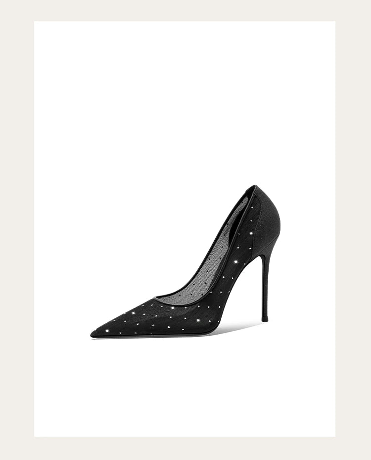 Black high-heeled shoe with studded details on a white background