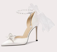 White high-heeled shoe with decorative bow and tulle on a white background