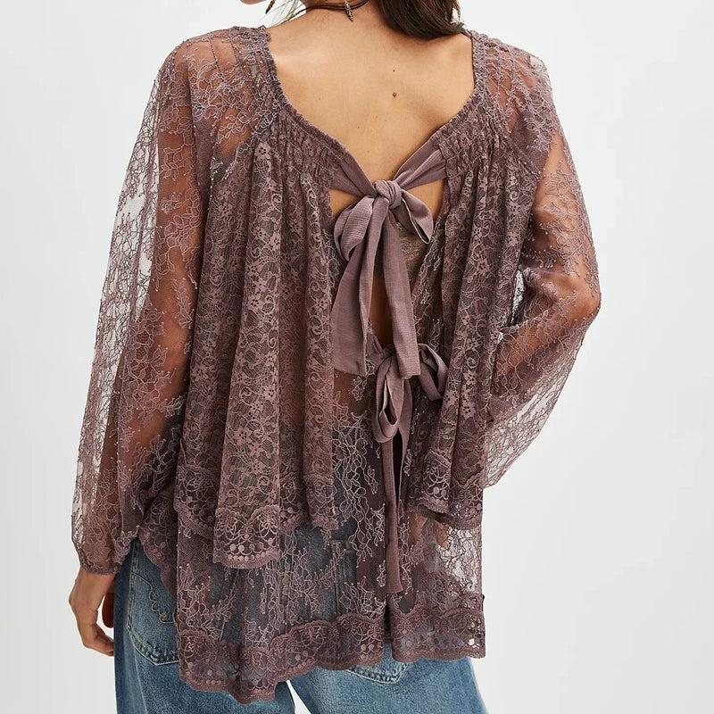 Lace top with open back and tied front on a plain background