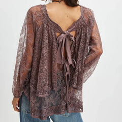 Lace top with open back and tied front on a plain background